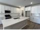 Bright kitchen featuring quartz countertops, white cabinetry, a center island, and stainless steel appliances at 17488 W Fulton St, Goodyear, AZ 85338