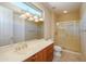 Bright bathroom featuring double vanity, large mirror, and glass-enclosed shower stall at 19541 N Rim Dr, Surprise, AZ 85374
