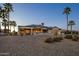 Rear exterior view of a modern home with manicured landscaping and palm trees at dusk at 19541 N Rim Dr, Surprise, AZ 85374