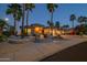 Inviting home featuring meticulous landscaping, stone accents and palm trees, set in a serene, well-lit neighborhood at 19541 N Rim Dr, Surprise, AZ 85374
