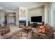 Cozy living room with a fireplace, large television, and travertine floors at 19541 N Rim Dr, Surprise, AZ 85374