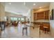 Open living room with a wet bar, barstool seating, and an outdoor view of the backyard at 19541 N Rim Dr, Surprise, AZ 85374