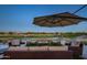 Covered patio with comfortable seating and a beautiful golf course view with outdoor fireplace at 19541 N Rim Dr, Surprise, AZ 85374