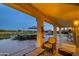 Inviting covered patio with golf course view, outdoor seating, and decorative wall art at 19541 N Rim Dr, Surprise, AZ 85374