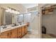 Well-lit bathroom with double sinks, a glass-enclosed shower, and closet at 20307 N Painted Sky Dr, Surprise, AZ 85374