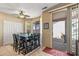 Bright dining area with a dark wood table, sliding door access to an outdoor patio, and a ceiling fan at 20307 N Painted Sky Dr, Surprise, AZ 85374