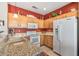 Bright kitchen with light wood cabinets, granite countertops, and white appliances at 20307 N Painted Sky Dr, Surprise, AZ 85374