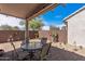 Relaxing covered patio seating area with desert landscaping and brick pavers at 20307 N Painted Sky Dr, Surprise, AZ 85374