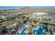 Aerial view of community pools, lounging areas, palm trees, amenities, and surrounding neighborhood at 20607 W Point Ridge Rd, Buckeye, AZ 85396