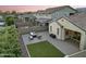 A serene backyard featuring a paver patio, fire pit, outdoor seating, and a green grass area at 20607 W Point Ridge Rd, Buckeye, AZ 85396