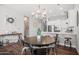 Cozy dining area with a round wooden table, modern lighting, and a seamless transition into the kitchen space at 20607 W Point Ridge Rd, Buckeye, AZ 85396