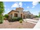 Exterior view of a charming home with desert landscaping and a welcoming entrance with a cozy seating area at 20607 W Point Ridge Rd, Buckeye, AZ 85396
