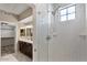 Bright bathroom featuring a glass-enclosed shower, a double vanity, and a walk-in closet at 2315 N 52Nd St # 102, Phoenix, AZ 85008