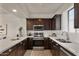 Modern kitchen featuring sleek countertops, stainless steel appliances, and dark wood cabinets and drawers at 2315 N 52Nd St # 102, Phoenix, AZ 85008