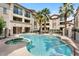Community pool with a hot tub and lounge chairs surrounded by palm trees and lush landscaping at 2315 N 52Nd St # 102, Phoenix, AZ 85008