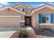 Home exterior features desert landscaping, a two-car garage, and vibrant blue shutters at 23955 W La Salle St, Buckeye, AZ 85326