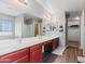 Spacious main bathroom boasts double vanity with red wood cabinets, large mirrors, and modern fixtures at 23955 W La Salle St, Buckeye, AZ 85326