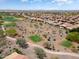 An aerial view showcases homes in a desert community near a golf course at 26725 W Marco Polo Rd, Buckeye, AZ 85396