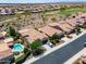 An aerial view of a neighborhood showcasing a home with a pool and desert landscaping at 26725 W Marco Polo Rd, Buckeye, AZ 85396