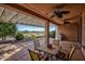 Relaxing covered patio with ceiling fans, a dining set, and views of the desert landscape at 26725 W Marco Polo Rd, Buckeye, AZ 85396