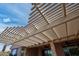 Back patio featuring decorative pergola, string lights, ceiling fans, and an outdoor dining area at 26725 W Marco Polo Rd, Buckeye, AZ 85396