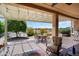 Inviting covered patio with outdoor dining, seating, lights and scenic desert landscape views at 26725 W Marco Polo Rd, Buckeye, AZ 85396