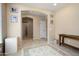 Hallway view displaying an arched doorway, neutral walls, tile floors, artwork and hall table at 26725 W Marco Polo Rd, Buckeye, AZ 85396
