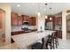 Kitchen features dark wood cabinets, granite countertops, stainless steel appliances, and a central island at 26725 W Marco Polo Rd, Buckeye, AZ 85396