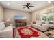 Comfortable living room with sofas, a flat screen television, ceiling fan, and a cozy area rug at 26725 W Marco Polo Rd, Buckeye, AZ 85396