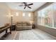 Cozy living room with neutral walls, ceiling fan, tan sofa, area rug and sunny window views at 26725 W Marco Polo Rd, Buckeye, AZ 85396