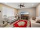 Comfortable living room with sofas, a flat screen television, ceiling fan, and a cozy area rug at 26725 W Marco Polo Rd, Buckeye, AZ 85396