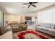 Open living room with plush seating, ceiling fan, and seamless flow into the dining and kitchen at 26725 W Marco Polo Rd, Buckeye, AZ 85396