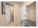 Open mud room featuring hooks and shelves, utility sink, and access to the laundry room at 26725 W Marco Polo Rd, Buckeye, AZ 85396