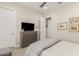 Neutral bedroom with ceiling fan, and dresser featuring a television, plus calming wall decor at 2835 E Donald Dr, Phoenix, AZ 85050