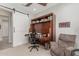 Office space with an armchair, shelving with books, and a built in Murphy bed desk setup at 2835 E Donald Dr, Phoenix, AZ 85050