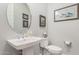 Tastefully decorated powder room with a pedestal sink, oval mirror, and coordinated decor at 2835 E Donald Dr, Phoenix, AZ 85050