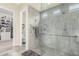 Accessible walk-in shower featuring grey tile, glass enclosure, and convenient grab bars at 2835 E Donald Dr, Phoenix, AZ 85050