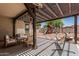 Inviting backyard featuring a covered patio, comfortable seating, a play structure, and mature trees at 3109 N Black Rock Rd, Buckeye, AZ 85396