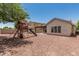 Expansive backyard features a playset, climbing wall, slide, and covered patio with hammock at 3109 N Black Rock Rd, Buckeye, AZ 85396