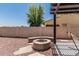 Large backyard featuring a fire pit with stone bench and easy access to the covered back patio at 3109 N Black Rock Rd, Buckeye, AZ 85396