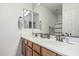 Bathroom with double sinks set in wood cabinets, a large mirror, and neutral-toned walls at 3109 N Black Rock Rd, Buckeye, AZ 85396