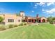 Charming exterior view of an outdoor patio space surrounded by red umbrellas and a well-manicured lawn at 3109 N Black Rock Rd, Buckeye, AZ 85396