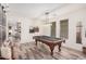 Spacious game room featuring a pool table, stylish light fixture, and wood-look tile floors at 3109 N Black Rock Rd, Buckeye, AZ 85396