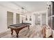 Open game room with pool table, wall-mounted TVs, guitars, and modern decor at 3109 N Black Rock Rd, Buckeye, AZ 85396
