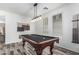Stylish game room with a classic pool table, elegant lighting, and wood-look flooring at 3109 N Black Rock Rd, Buckeye, AZ 85396