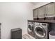 Functional laundry room with front-load washer and dryer, upper cabinets, and folding counter at 3109 N Black Rock Rd, Buckeye, AZ 85396
