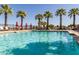 Sparkling community swimming pool surrounded by palm trees, lounge chairs, and shade umbrellas at 3109 N Black Rock Rd, Buckeye, AZ 85396