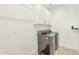 Laundry room featuring side-by-side gray washer and dryer, with white cabinets above at 3136 E Cheryl Dr, Phoenix, AZ 85028