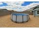 Backyard view with above-ground pool, rock landscaping and privacy fence at 36463 W San Alvarez Ave, Maricopa, AZ 85138