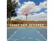 Outdoor basketball court featuring a blue painted surface with visible white line markings and a red basketball hoop at 36463 W San Alvarez Ave, Maricopa, AZ 85138